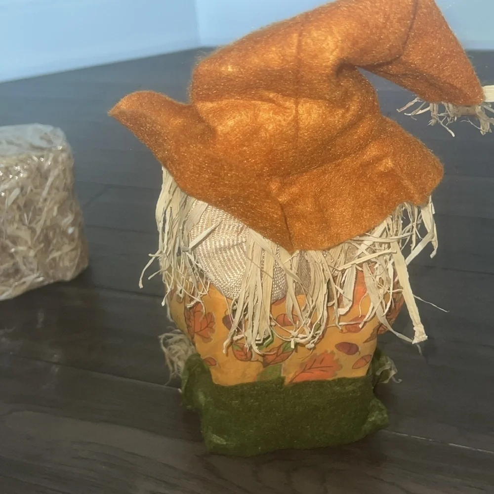 Scarecrow figurine with straw Bale